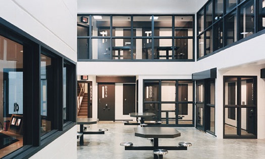 White walls with windows that look over a metal table common area in the Douglas County Jail