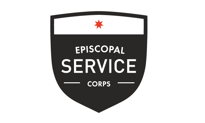 A shield shaped patch with white text reading Episcopal Service Corps on a black background and a white bar at the top with a red seven pointed star.