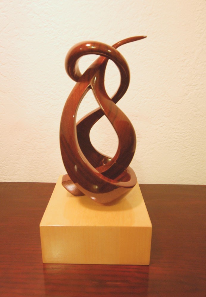 A sculpture of three interwoven wooden strands.
