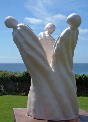 A statue of three armless humanoid figures that are joined together at the base.